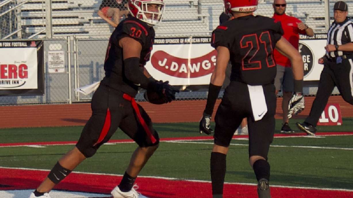 American Fork tight end Noah Moeak (30) celebrates a touchdown with teammate Peyton Rees (21) during the Cavemen's 45-14 win over Weber, Friday, Aug. 20, 2021.