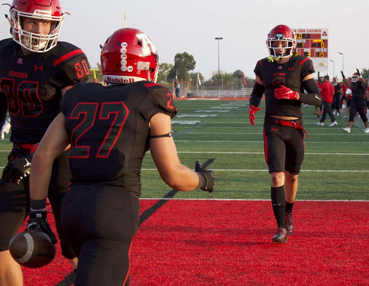 American Fork's Trey Roberts (27) celebrates a touchdown with teammate Fisher Ingersoll (2) during the Cavemen's 45-14 win over Weber, Friday, Aug. 20, 2021.