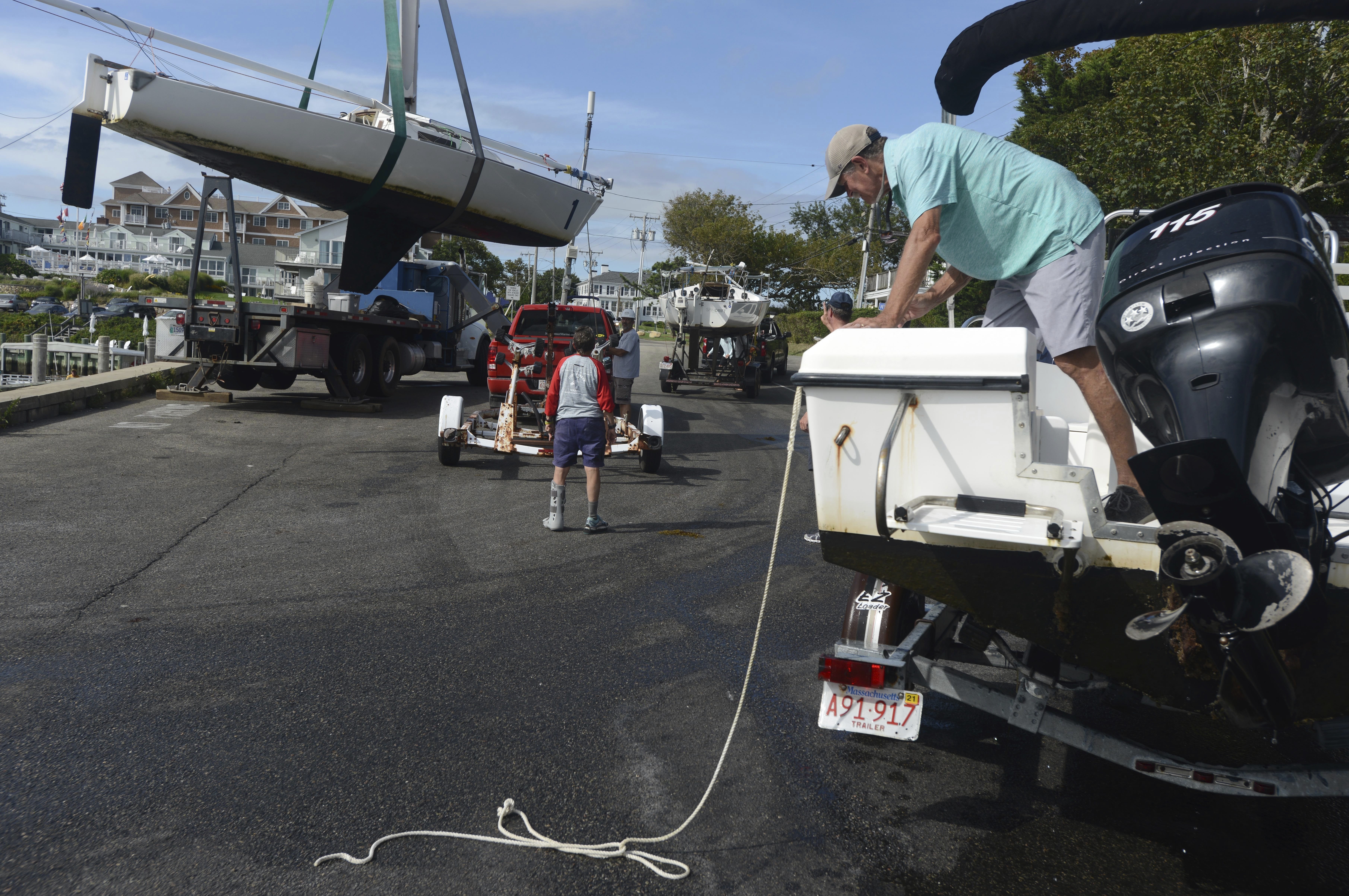 Baxter Crane Company hauls one of the Hyannis Yacht Club J22 sailboats onto a trailer Friday in Hyannis. Mass.