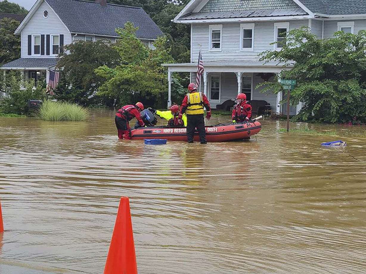 In this photo provided by Mayor Chris Slavicek, emergency personnel and first responders work to help residents after heavy rains from Henri flooded the area, Sunday, in Helmetta, N.J.