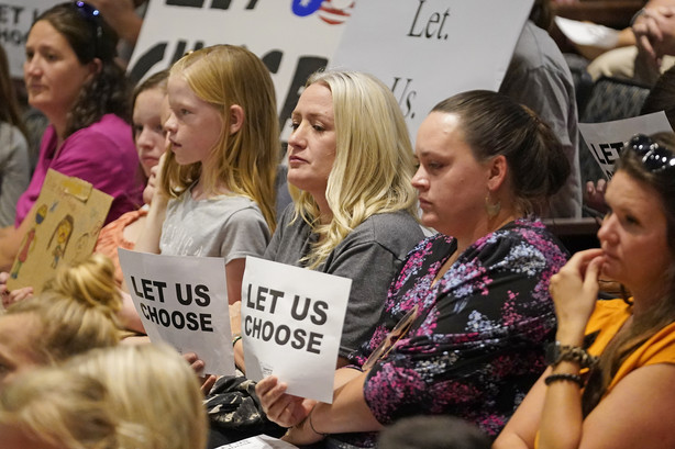 People listen to the Salt Lake County Council before their vote to overturn the health department's "order of restraint" that would have required K-6 students to wear masks on Aug. 12, 2021. A new poll finds that a majority of Americans support mask and vaccine mandates for students and teachers in K-12 schools.