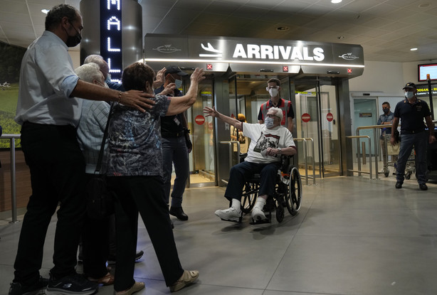 A 97-year-old retired American soldier Martin Adler, right, is welcomed upon his arrival by Giulio Mafalda Giuliana Naldi, who he saved during World War II, at the Bologna airport in Italy on Monday.