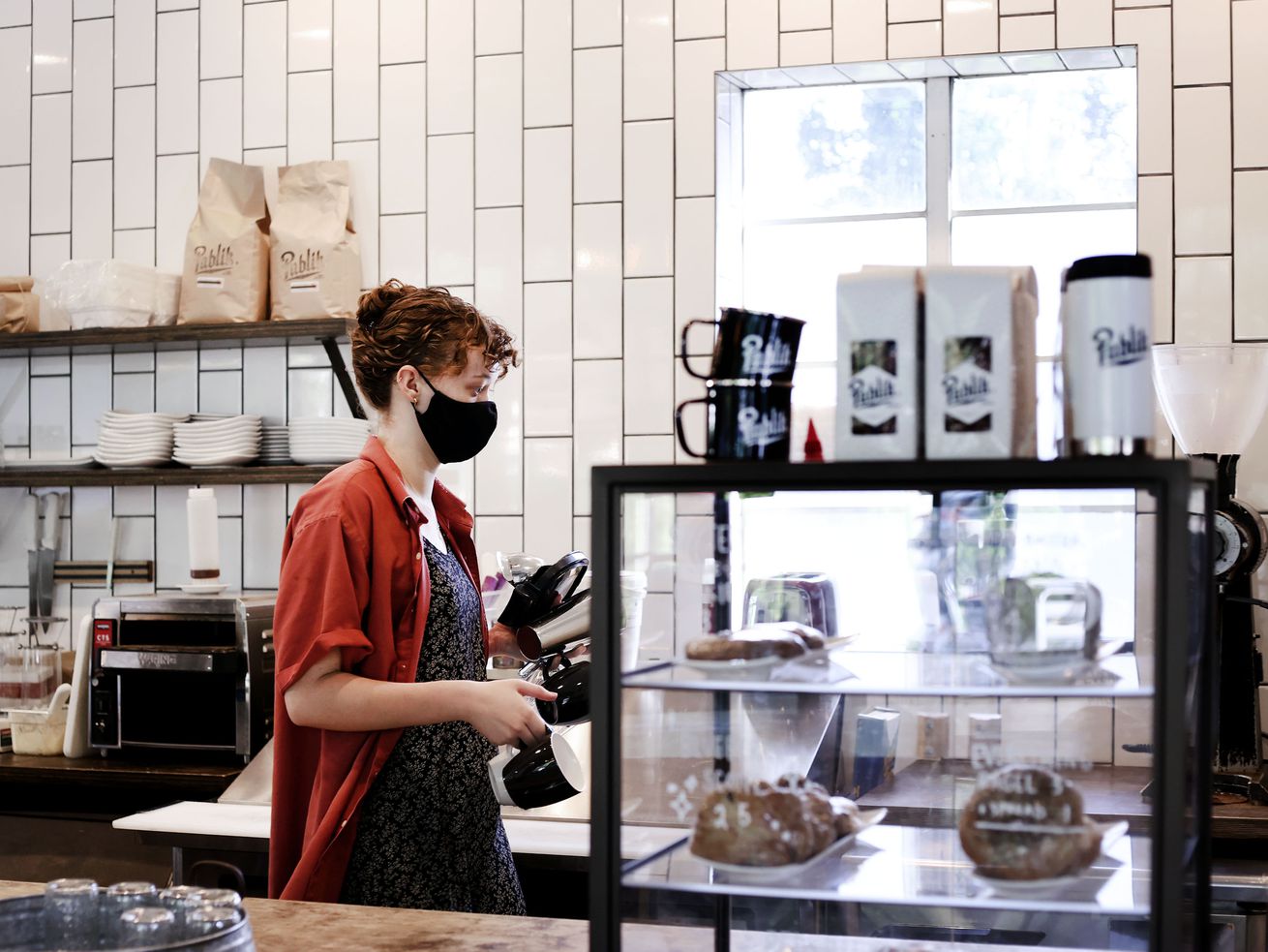 Kate Comstock works at Publik Coffee Roasters in Salt Lake City on Friday. Utah businesses are doing well but cautious about coming out of the COVID-19 pandemic as the delta variant rages.
