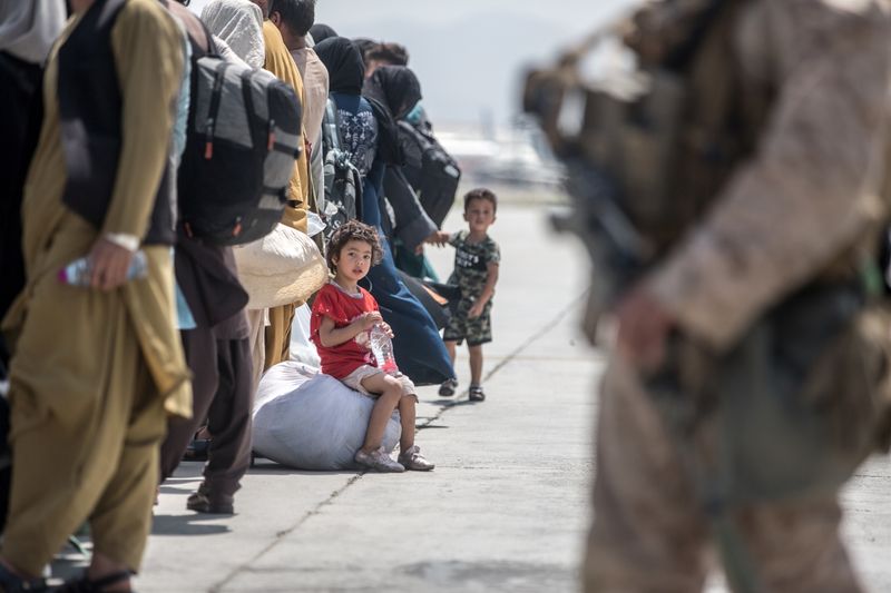 A child waits with her family to board a U.S. Air Force Boeing C-17 Globemaster III during an evacuation at Hamid Karzai International Airport, Afghanistan, Sunday.