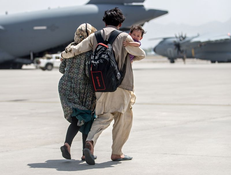 A family walks towards a U.S. plane at Hamid Karzai International Airport, Afghanistan, Sunday.