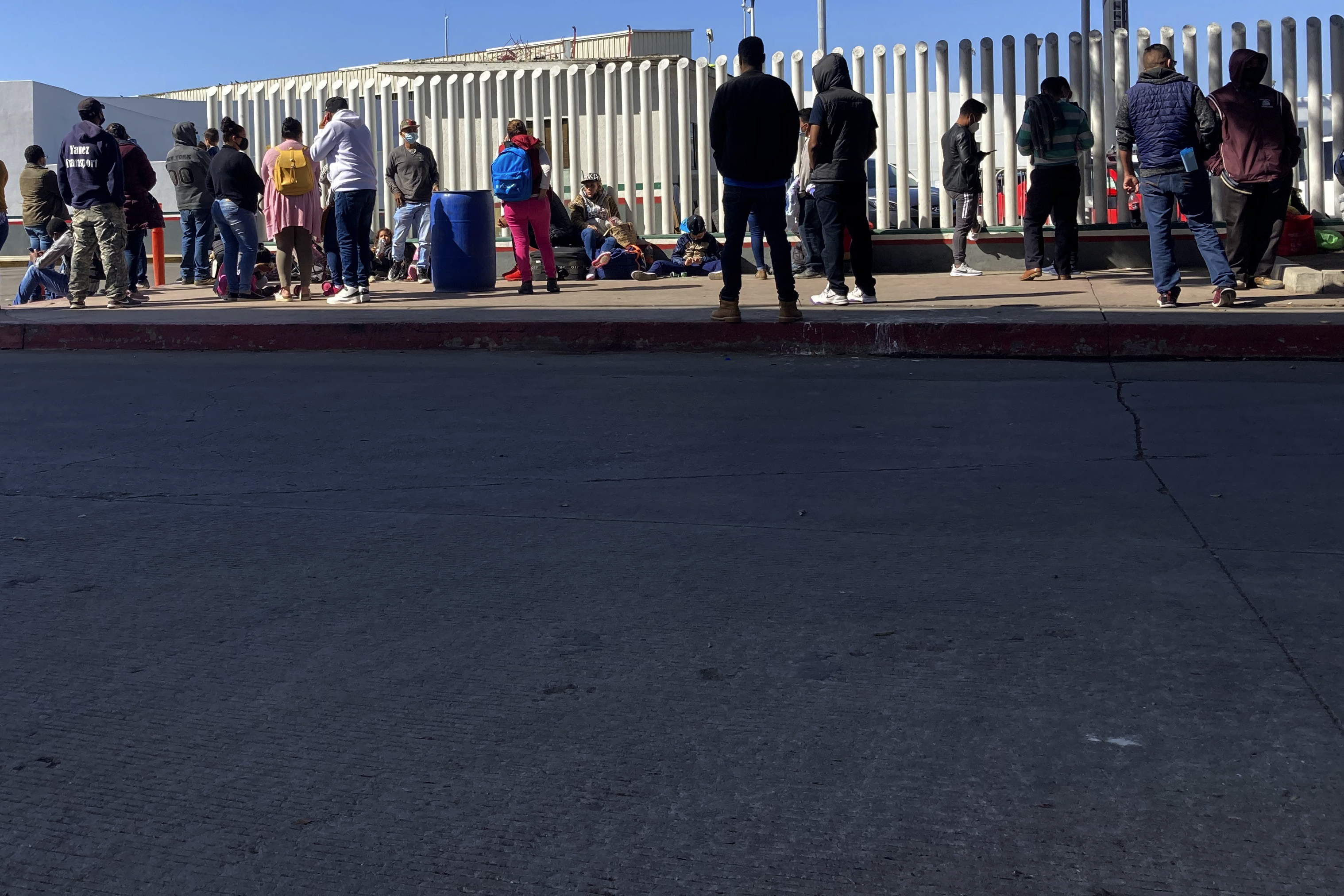 Migrants waiting to cross into the United States wait for news at the border crossing on Feb. 17 in Tijuana, Mexico. The U.S. Supreme Court on Tuesday denied President Joe Biden's bid to rescind an immigration policy, implemented Donald Trump, that forced thousands of asylum seekers to stay in Mexico awaiting U.S. hearings.