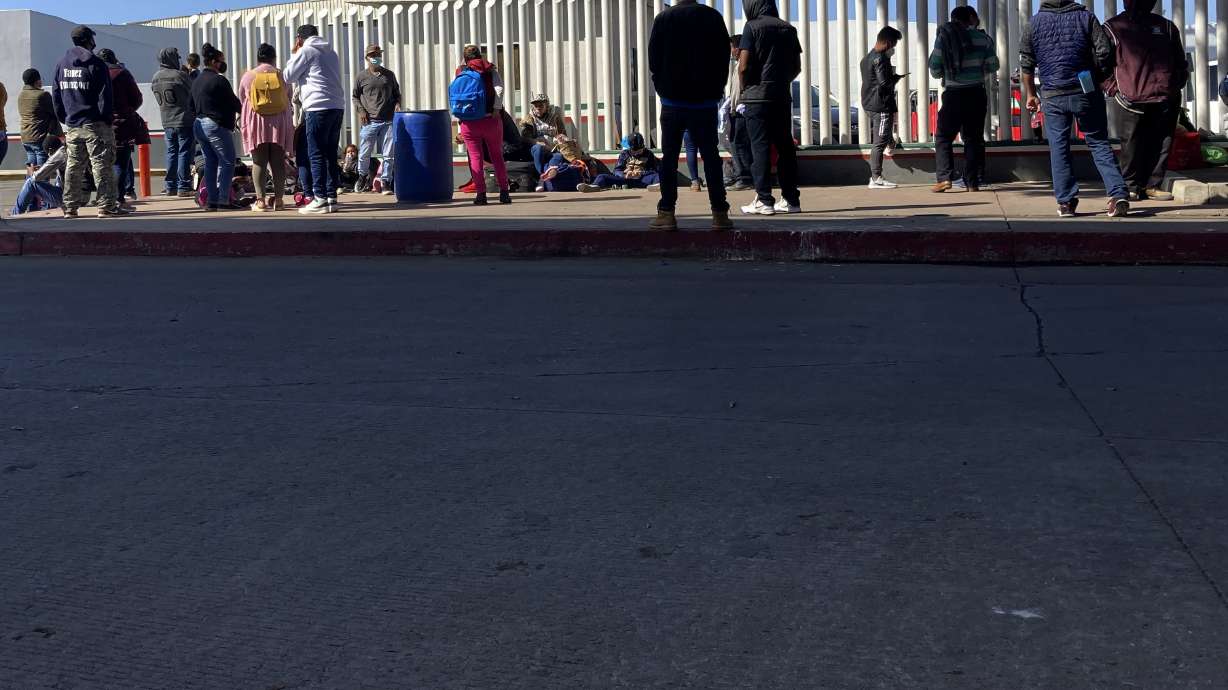 Migrants waiting to cross into the United States wait for news at the border crossing on Feb. 17 in Tijuana, Mexico. The U.S. Supreme Court on Tuesday denied President Joe Biden's bid to rescind an immigration policy, implemented Donald Trump, that forced thousands of asylum seekers to stay in Mexico awaiting U.S. hearings.