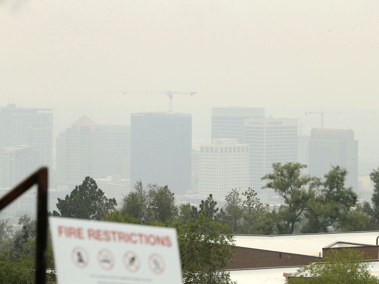 A fire restrictions warning sign is posted in the Avenues while the view of Salt Lake City is obscured by smoke from the California and Oregon wildfires on Friday, Aug. 6, 2021. Wildfires from the West have produced huge columns of smoke that have drifted as far east as New York, creating some of the worst air quality that state has seen in 15 years.