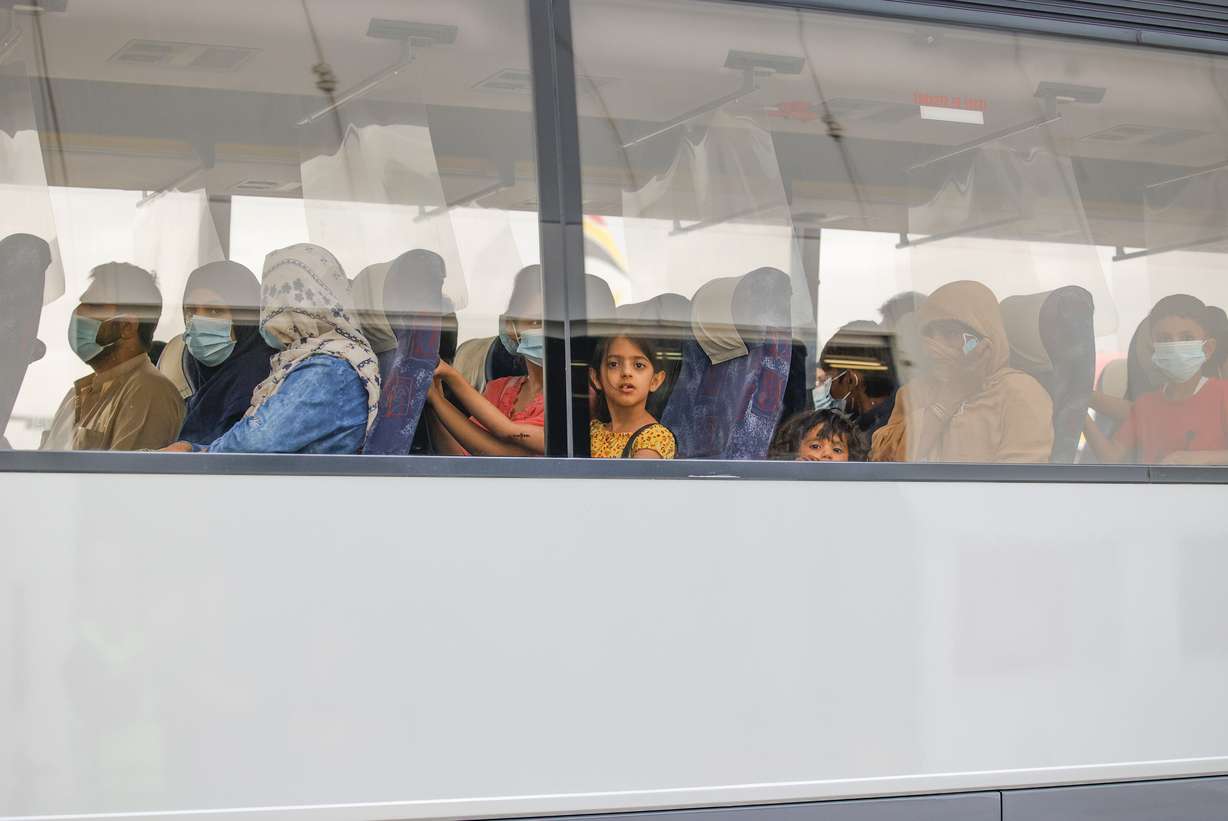 People wait in a bus after disembarking from a Belgian chartered plane, as part of an evacuation from Afghanistan Thursday.