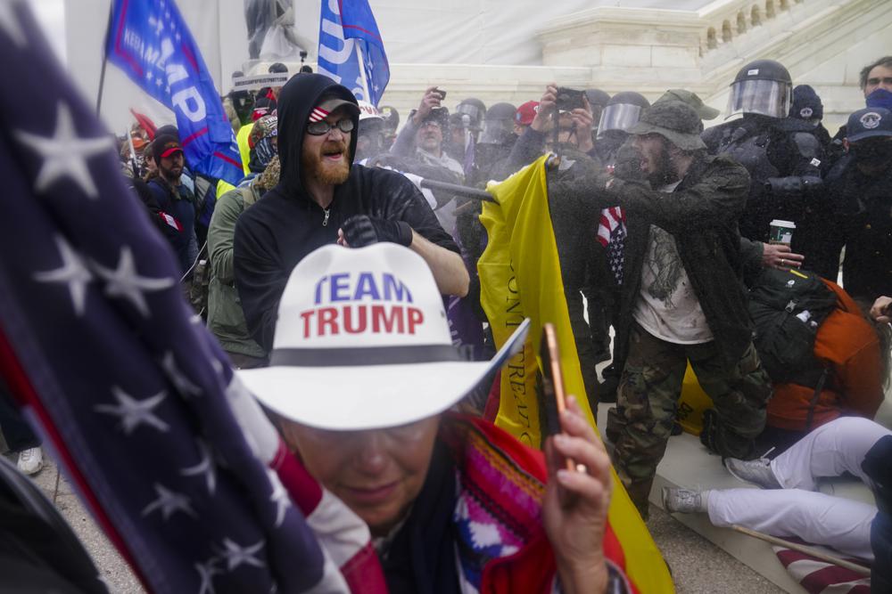 In this Jan. 6, 2021 photo, insurrections loyal to President Donald Trump try to break through a police barrier at the Capitol in Washington. U.S. Capitol Police officers who were attacked and beaten during the Capitol riot filed a lawsuit on Thursday against former President Donald Trump, his allies and members of far-right extremist groups, accusing them of intentionally sending insurrectionists to disrupt the congressional certification of the election in January.