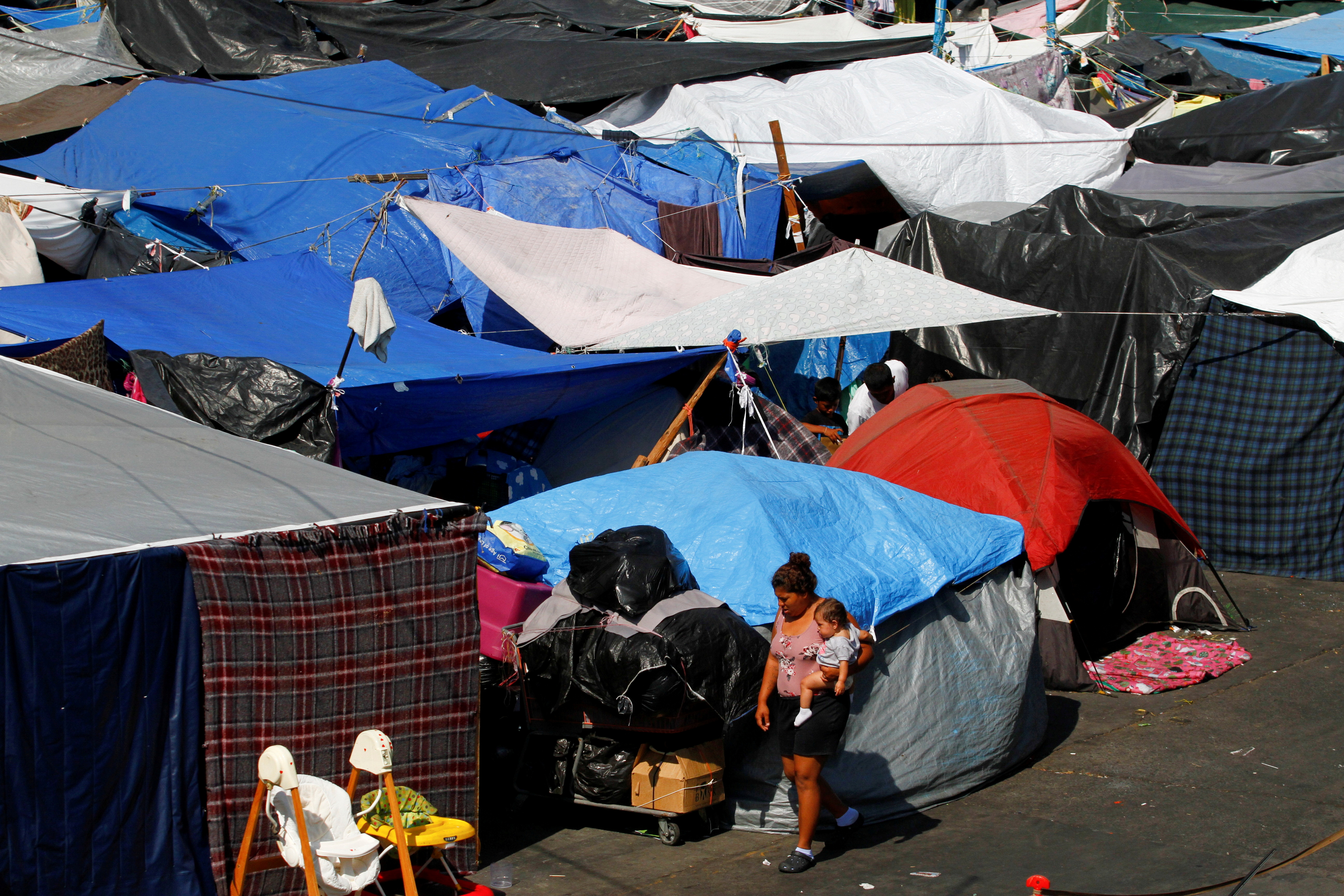Asylum-seeking migrants are pictured at a makeshift camp after the U.S. Supreme Court ordered to uphold an immigration policy implemented under former President Donald Trump that forced thousands of asylum seekers to stay in Mexico to await U.S. hearings, at El Chaparral crossing port with the U.S., in Tijuana, Mexico on Tuesday. 