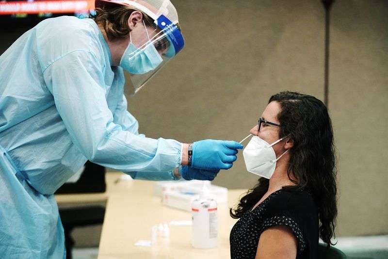 Ryan Jensen gives Utah Valley University instructor
Lauren Brooks a COVID-19 test at the university in Orem on
Thursday.
