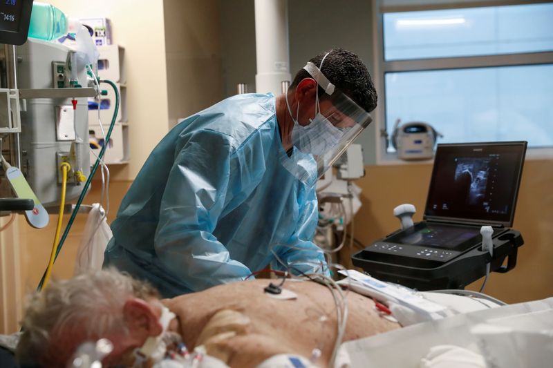 A critical care respiratory therapist works with a COVID-19 patient in the intensive care unit at Sarasota Memorial Hospital in Sarasota, Florida, on Feb. 11.