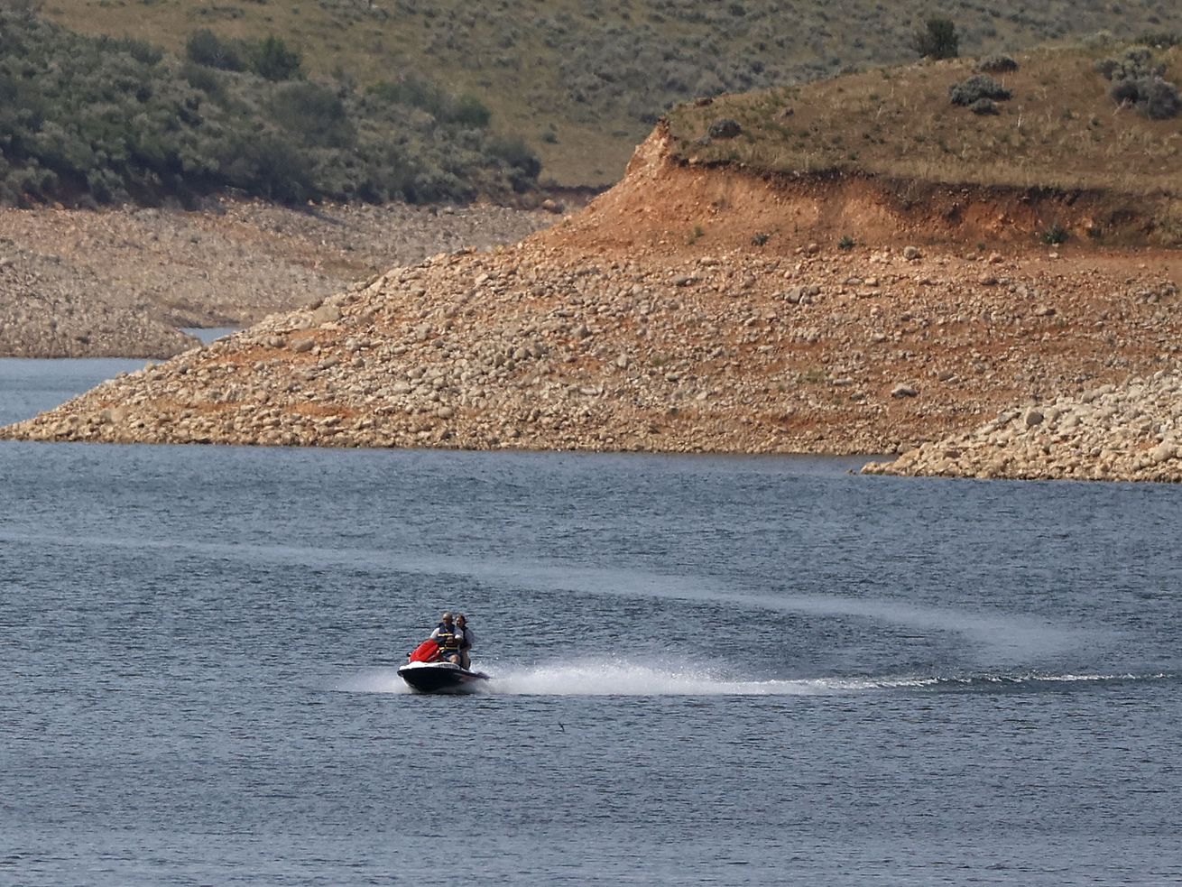 Low water levels are visible as a person rides a
personal watercraft on East Canyon Reservoir in Morgan County
during a drought in Utah on June 16. Utah
officials and water managers are taking a deeper look at potential
sites for new reservoirs to capture precipitation for water
storage.