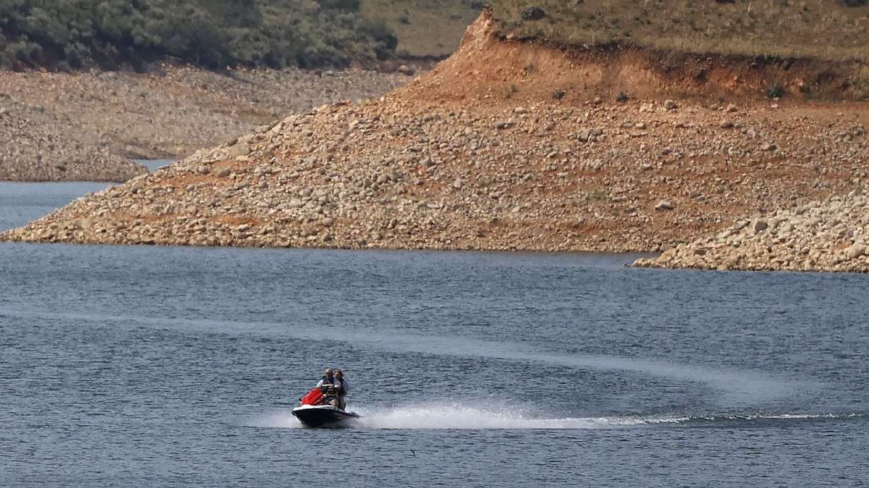 Low water levels are visible as a person rides a
personal watercraft on East Canyon Reservoir in Morgan County
during a drought in Utah on June 16. Utah
officials and water managers are taking a deeper look at potential
sites for new reservoirs to capture precipitation for water
storage.