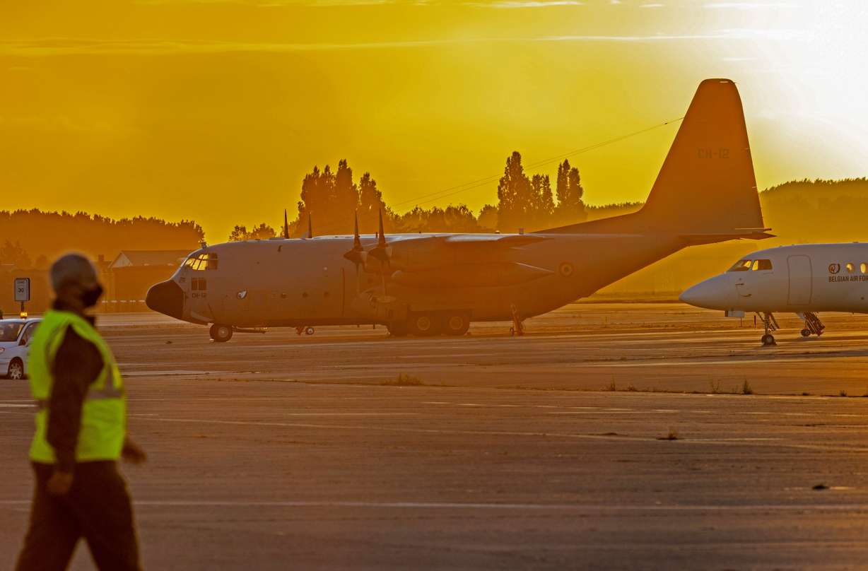 Military personnel walk by Belgian military planes, used as part of an evacuation from Afghanistan, upon arrival at Melsbroek Military Airport in Melsbroek, Belgium, on Friday.