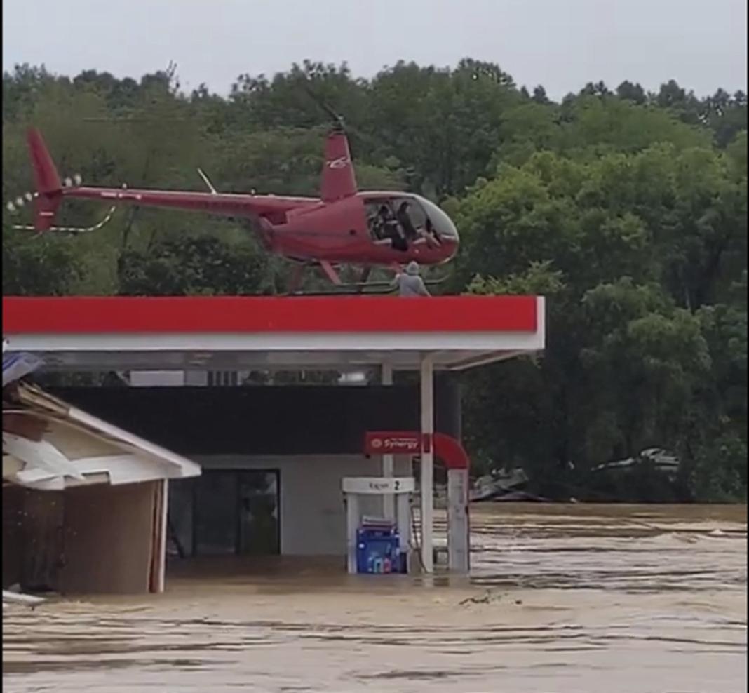 This image from video provided by Jeani Rice-Cranford shows Nashville-based helicopter pilot Joel Boyers rescuing people from a rooftop on Aug. 21 in Waverly, Tenn. Boyers, who co-owns Helistar Aviation, said he ended up rescuing 17 people that day. He’s proud of that, but said he’s the one who should be thanking them.