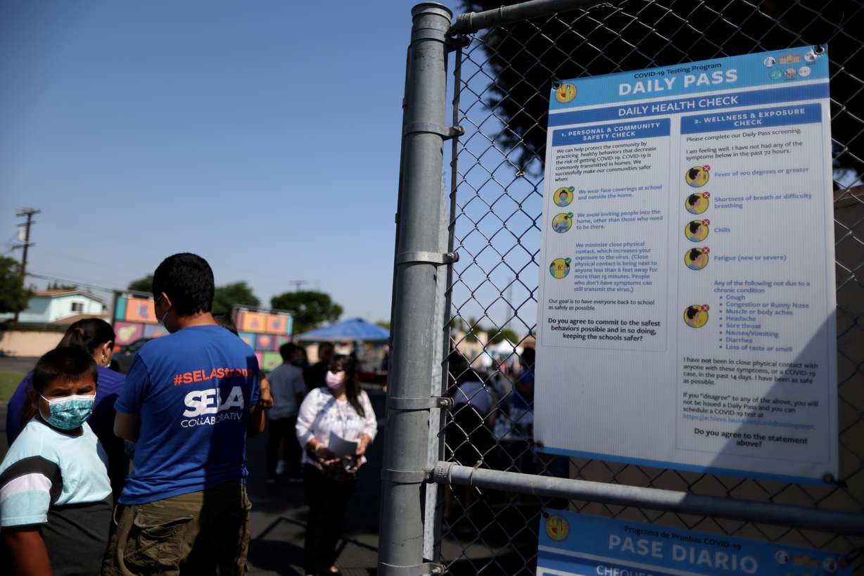 People wait in line at a school for coronavirus disease testing and vaccines in South Gate, Los Angeles, California, on Aug. 12.