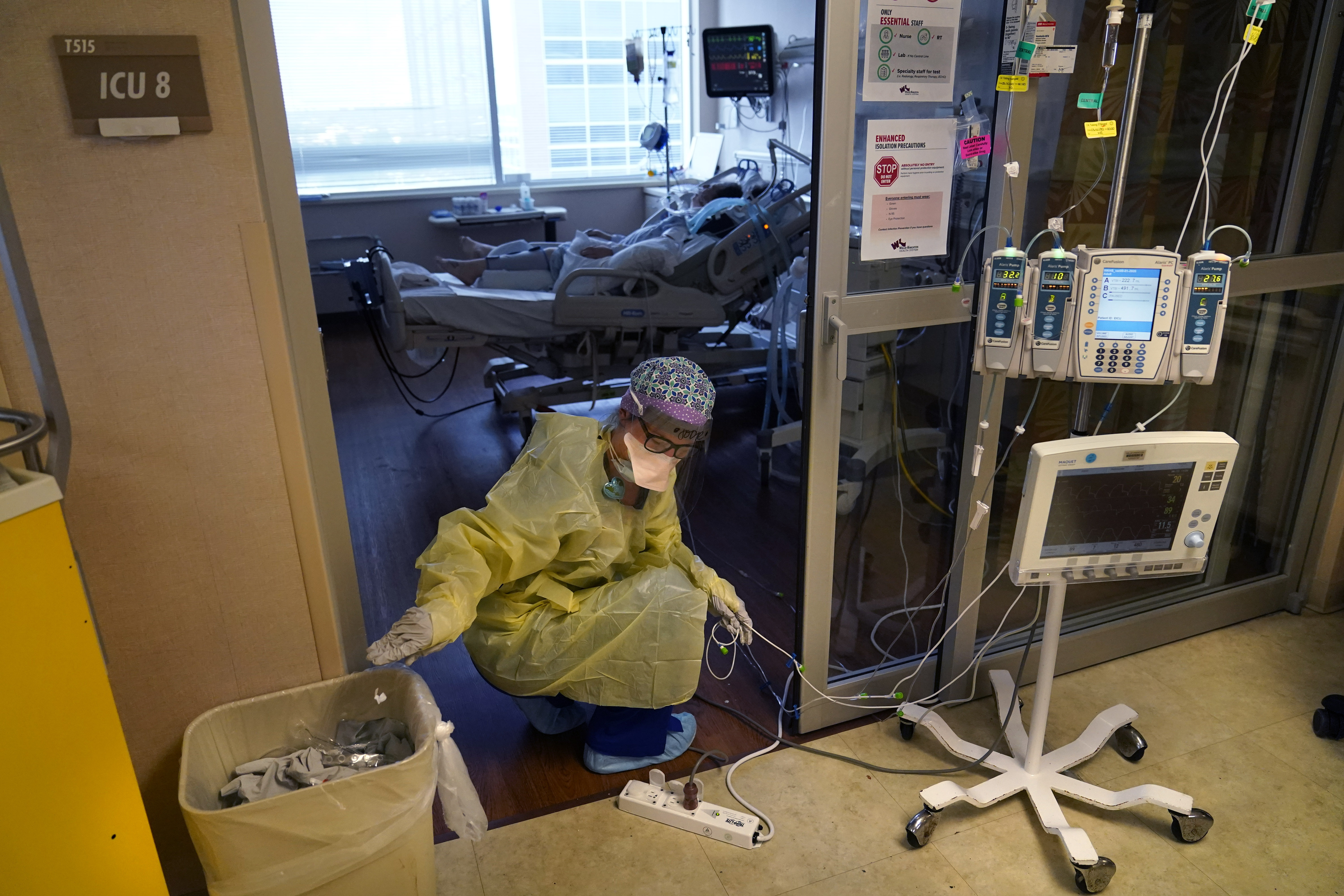 Jodie Ford, an ICU nurse, moves electrical cords for medical machines, outside the room of a patient suffering from COVID-19, in an intensive care unit at the Willis-Knighton Medical Center in Shreveport, La., on Aug. 17.