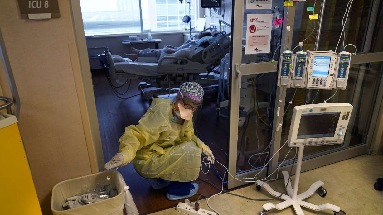 Jodie Ford, an ICU nurse, moves electrical cords for medical machines, outside the room of a patient suffering from COVID-19, in an intensive care unit at the Willis-Knighton Medical Center in Shreveport, La., on Aug. 17.