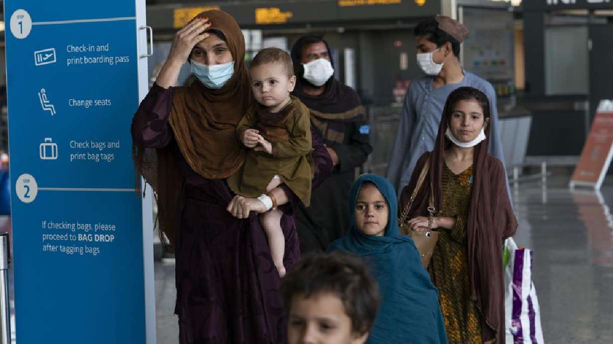 Families evacuated from Kabul, Afghanistan, walk through the terminal before boarding a bus after they arrived at Washington Dulles International Airport, in Chantilly, Va., on Friday.
