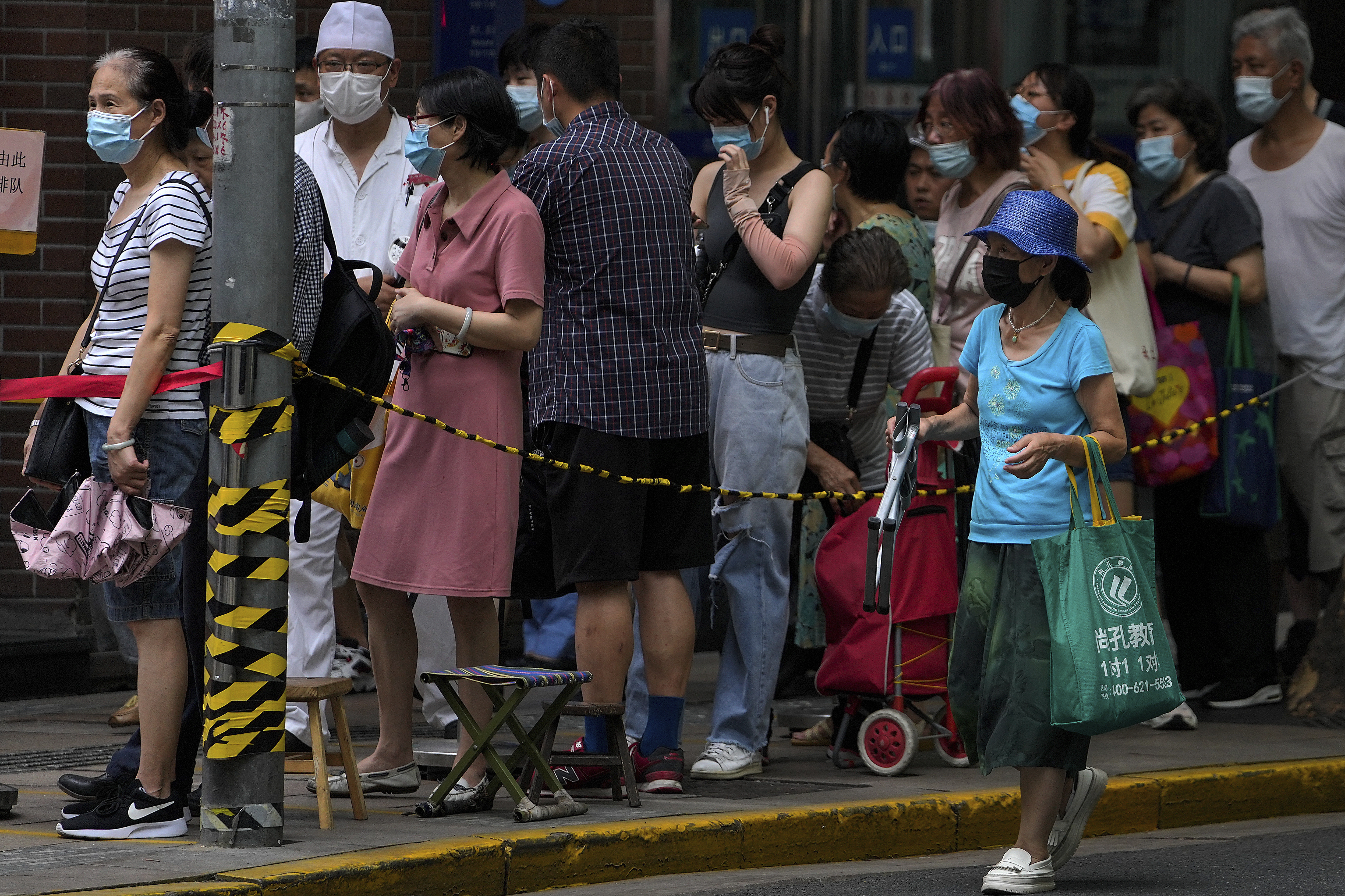 People wearing face masks to help curb the spread of the coronavirus line up outside a bakery shop to buy cookies in Shanghai, China on Friday.