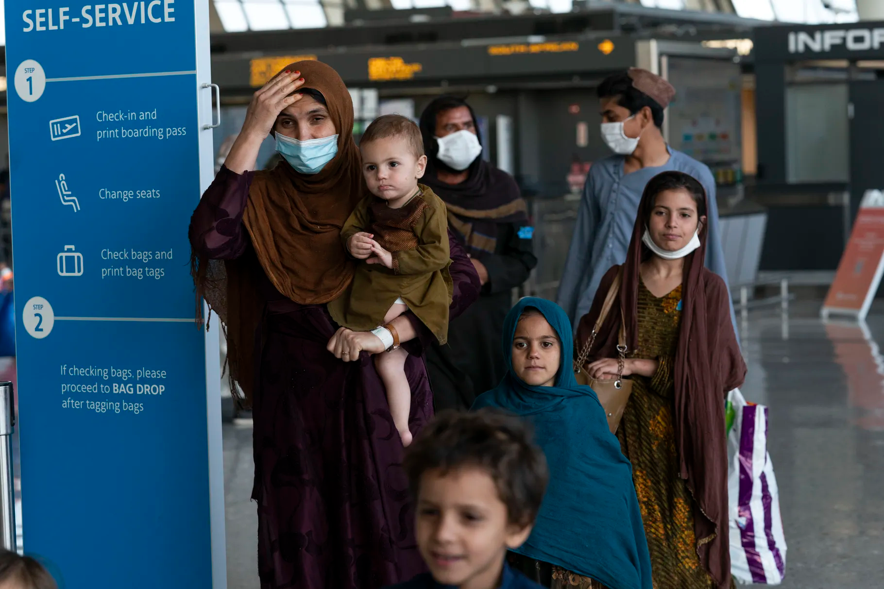 Families evacuated from Kabul, Afghanistan, walk through the terminal before boarding a bus after they arrived at Washington Dulles International Airport, in Chantilly, Va., on Friday, Aug. 27, 2021. Since Monday, thousands of Afghan Christians have left Afghanistan with the help of nongovernmental organizations, including The Nazarene Fund, which is led by Operation Underground Railroad’s Tim Ballard and conservative radio personality Glenn Beck, among others.