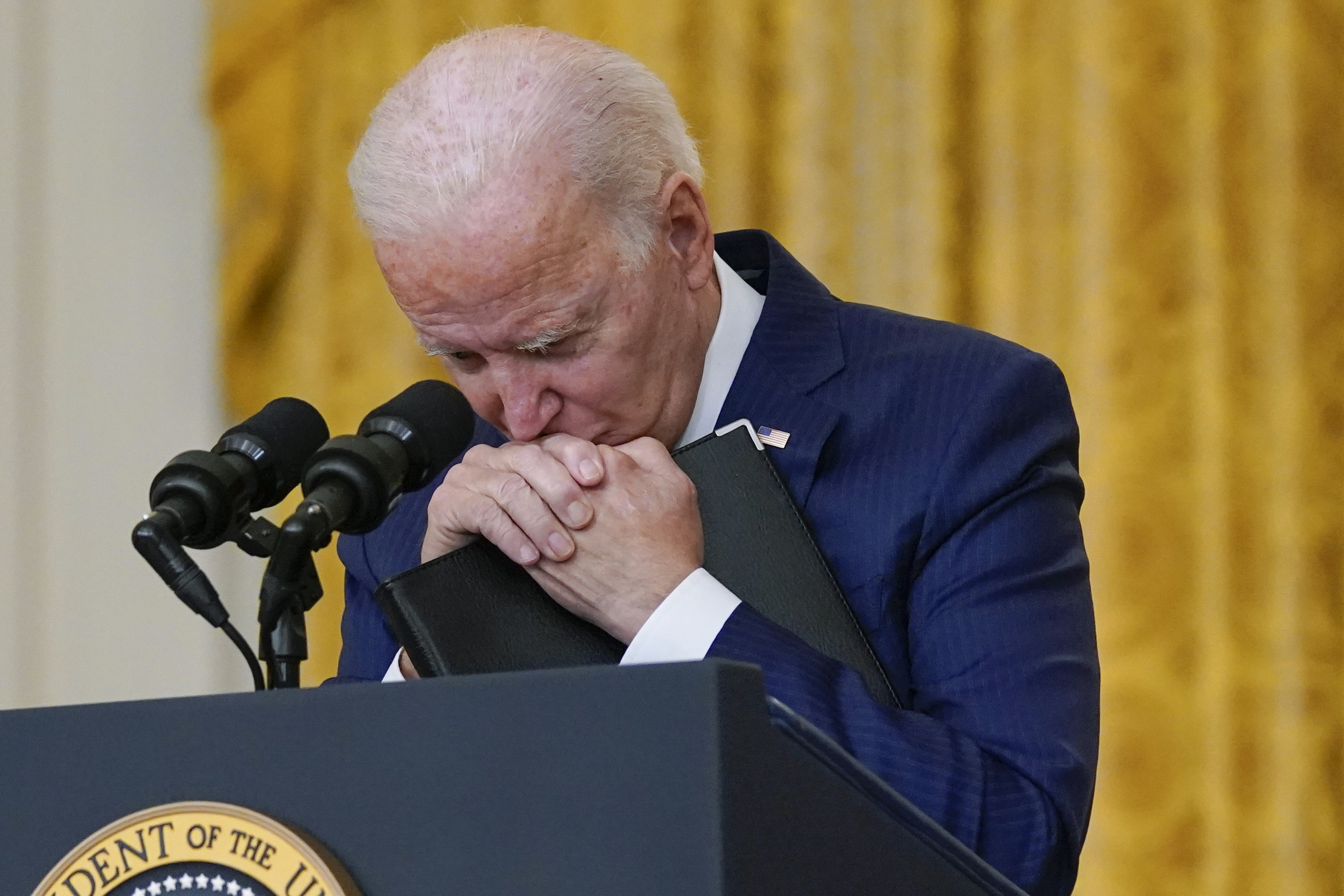 President Joe Biden pauses as he listens to a question about the bombings at the Kabul airport that killed at least 12 U.S. service members, from the East Room of the White House, Thursday in Washington.