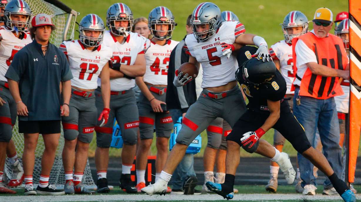 Mountain Ridge running back Cade Uluave (5) gets tackled by Wasatch's Quezon Villa in a high school football game on Friday, Aug. 27, 2021, at Wasatch High School in Heber. Mountain Ridge won 40-30.