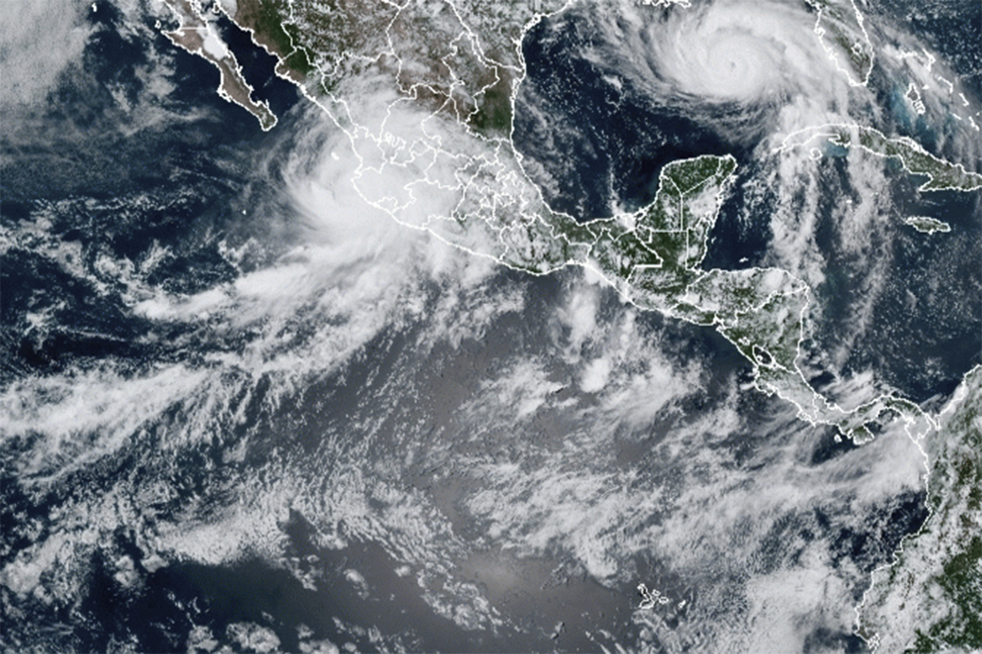 This image provided by the National Oceanic and Atmospheric Administration (NOAA) shows severe weather systems, Hurricane Nora, upper left, and Hurricane Ida, upper right, over the North American continent on Saturday, Aug. 28, 2021. Hurricane Nora is churning northward up Mexico's Pacific Coast toward the narrow Gulf of California, after making a sweep past the Puerto Vallarta area. 