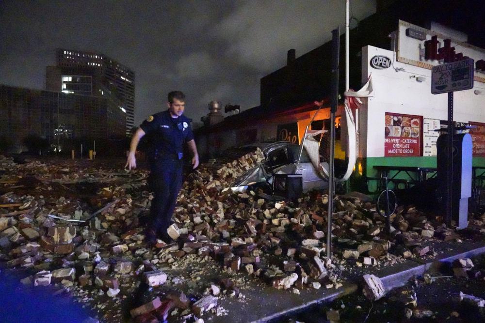 New Orleans Police detective Alexander Reiter, looks over debris from a building that collapsed during Hurricane Ida in New Orleans, Monday. Hurricane Ida knocked out power to all of New Orleans and inundated coastal Louisiana communities on a deadly path through the Gulf Coast that is still unfolding and promises more destruction.