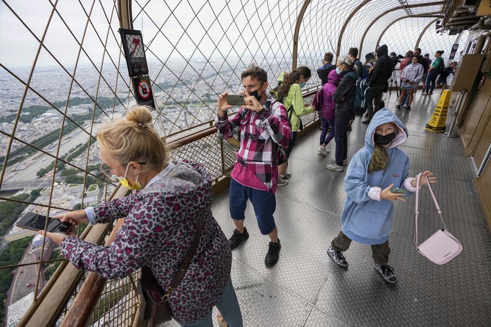 In this July 16 photo, visitors enjoy the view from the top of the Eiffel Tower in Paris. The European Union is expected to recommend that its member states reinstate restrictions on tourists from the U.S. because of rising coronavirus infection levels in the country, EU diplomats said Monday.