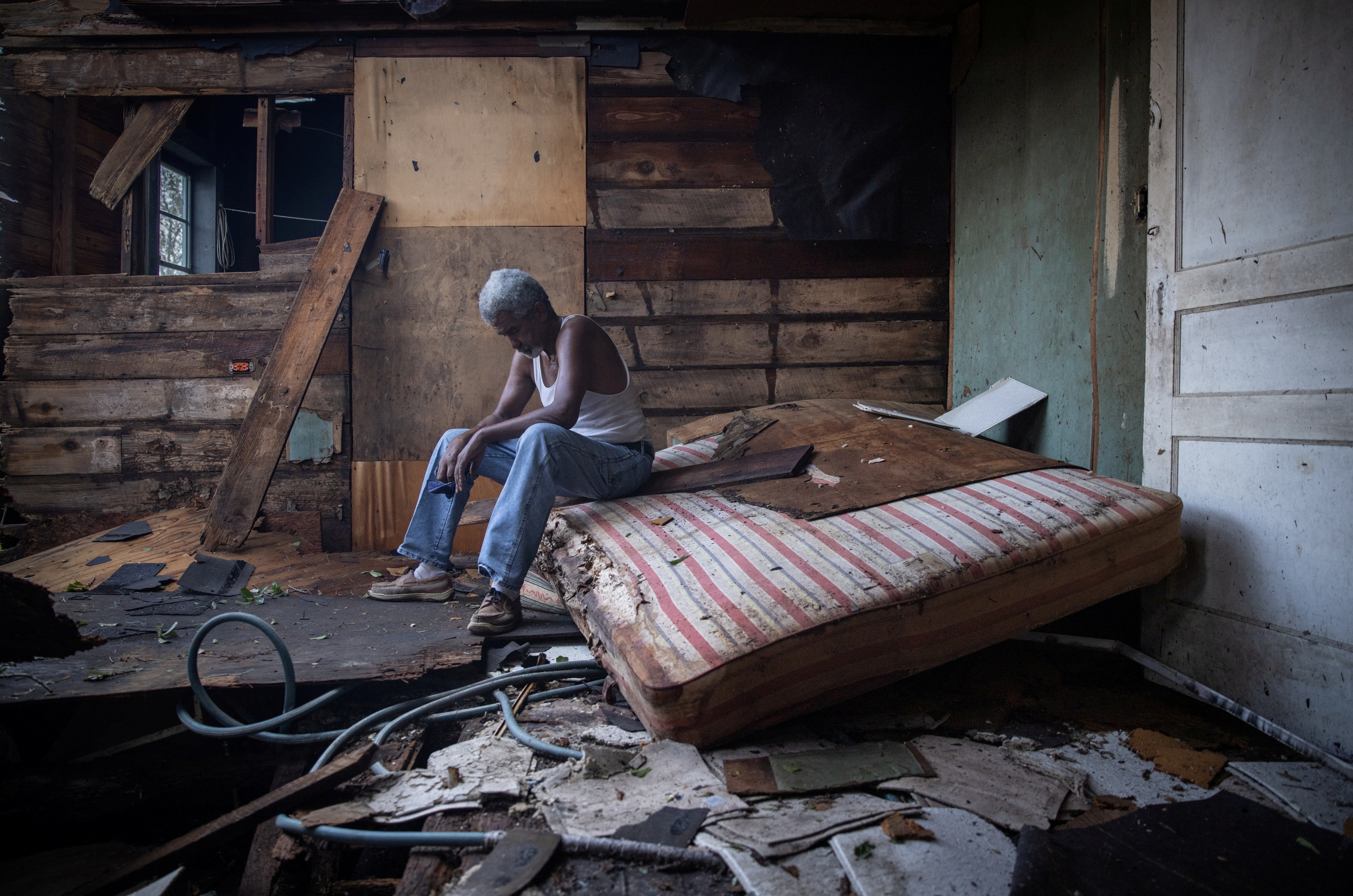 Theophilus Charles, 70, sits inside his house which was heavily damaged by Hurricane Ida in Houma, Louisiana, on Monday.