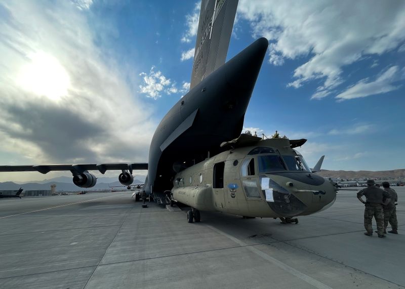 A CH-47 Chinook is loaded onto a U.S. Air Force C-17 Globemaster III at Hamid Karzai International Airport in Kabul, Afghanistan, Saturday. The Chinook is one of the pieces of equipment returning to the U.S. as the military mission in Afghanistan comes to an end. 
