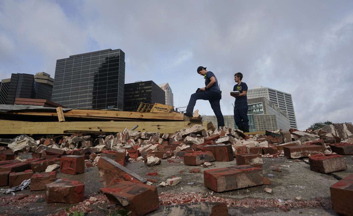 New Orleans Firefighters assess damage as they look through debris after a building collapsed from the effects of Hurricane Ida, on Monday in New Orleans. All of New Orleans lost power right around sunset Sunday as the hurricane blew ashore on the 16th anniversary of Katrina, leading to an uneasy night of pouring rain and howling wind.