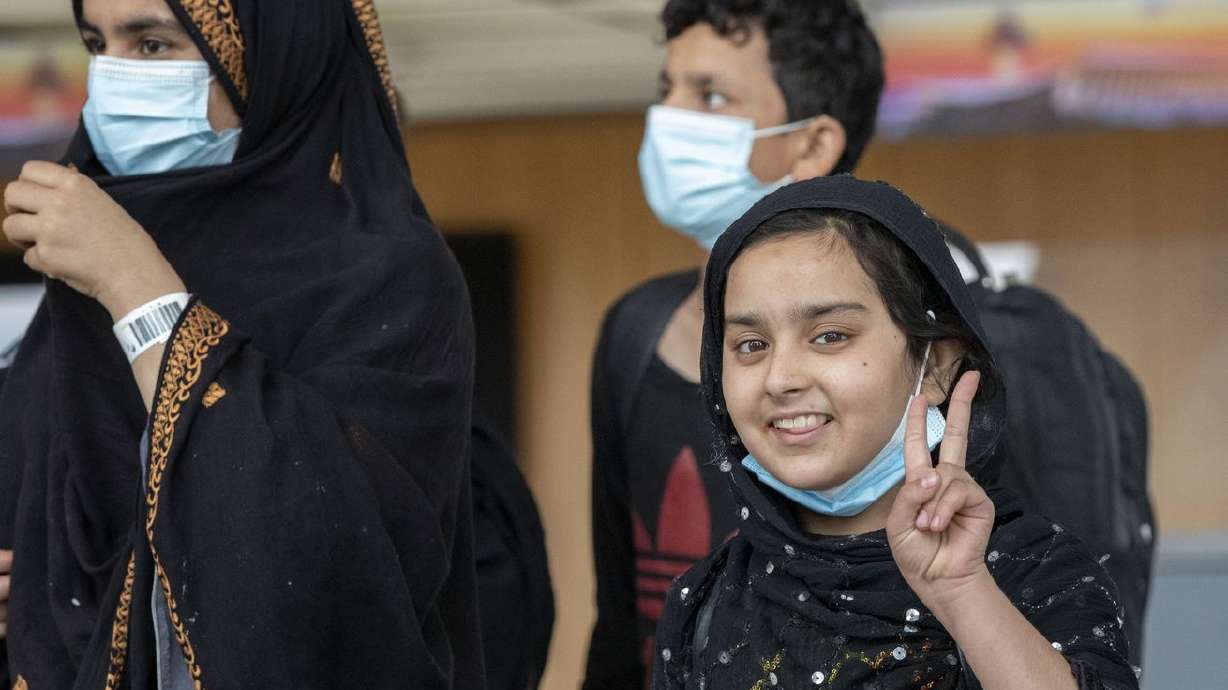 A child evacuated from Kabul, Afghanistan, gestures at Washington Dulles International Airport, in Chantilly, Va., on Tuesday. The U.S. State Department recently released a list of 19 "welcoming communities" in the U.S. where Afghan citizens fleeing the Taliban are recommended to settle once visas are granted.