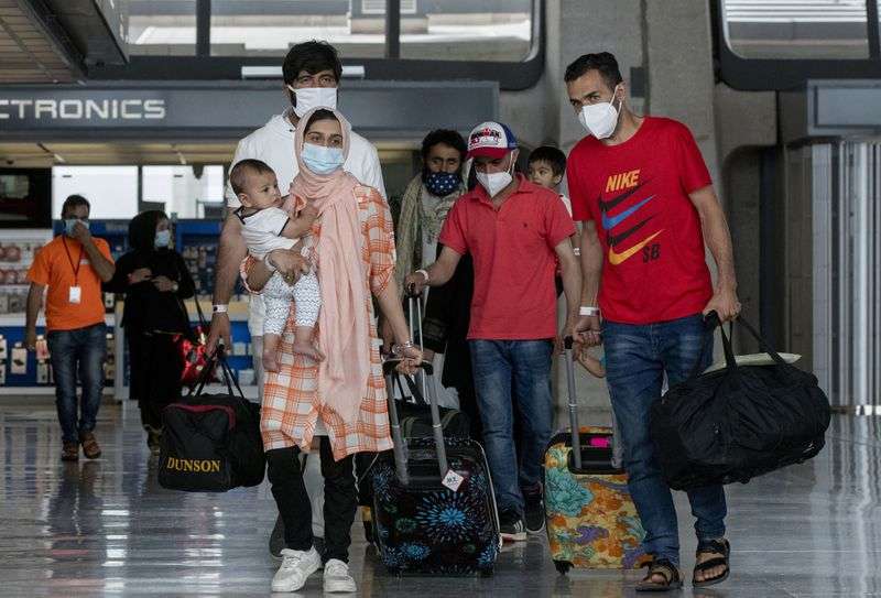 Families evacuated from Kabul, Afghanistan, walk
through the terminal to board a bus after they arrived at
Washington Dulles International Airport, in Chantilly, Va., on
Tuesday, Aug. 31, 2021.