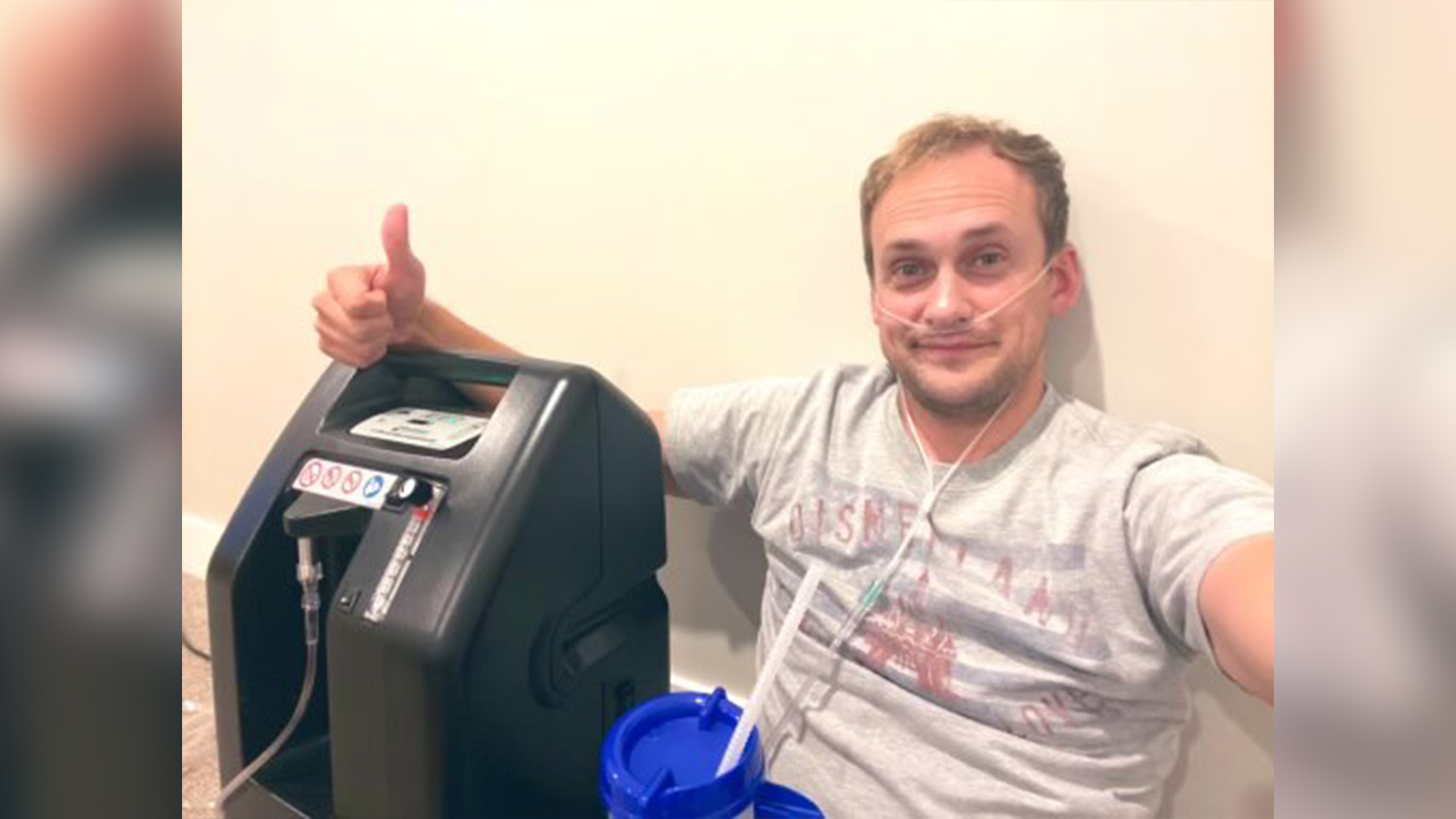 BYUtv reporter and SportsNation host Spencer Linton sits on the floor, hooked up to oxygen as he recovers from a severe COVID-19 breakthrough case.