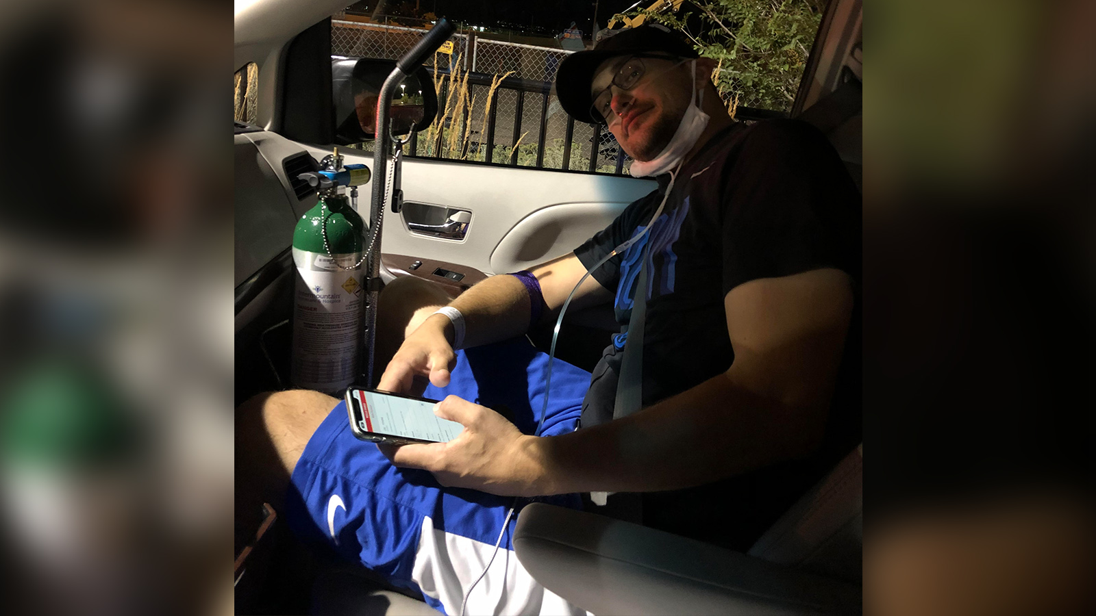 BYUtv reporter and SportsNation host Spencer Linton sits in a car, hooked up to oxygen as he leaves the American Fork Hospital after being treated for a severe COVID-19 breakthrough case on Aug. 22.