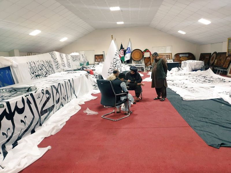 Unidentified people are surrounded by Taliban flags at an unidentified location in this handout photo uploaded to social media on Wednesday.