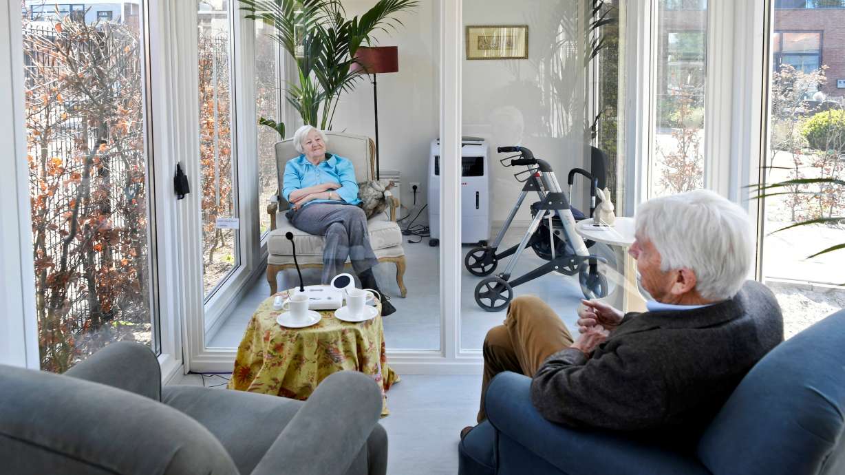 A man visits his wife at a care facility for elderly people with dementia in a glass house that has been built to combat loneliness in Wassenaar, Netherlands, April 9, 2020. With populations aging, the number of those who suffer with dementia is projected to rise to 78 million by 2030 and 139 million by 2050, the WHO said in a report.