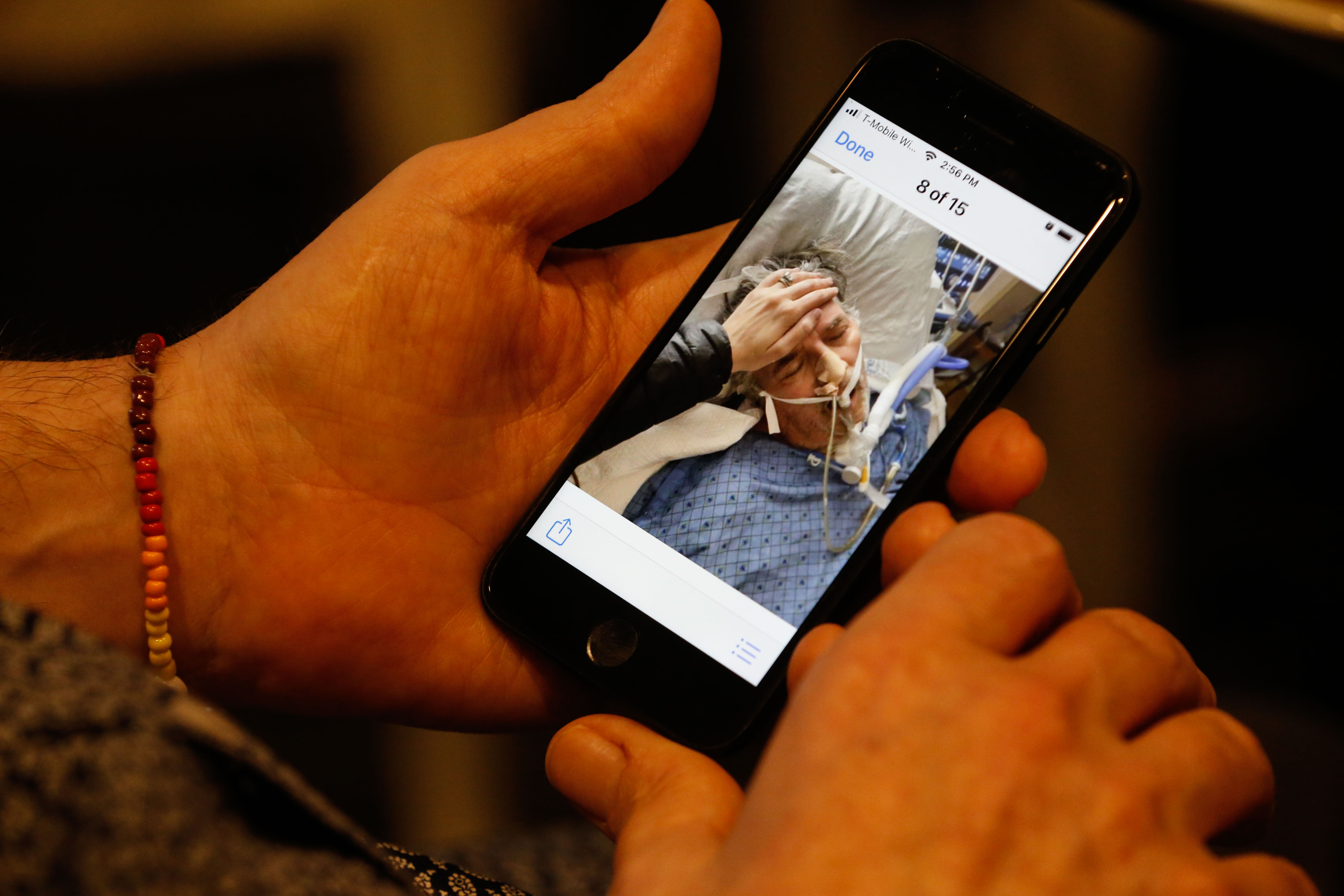 Thomas Kearl shows a photo on his phone of his time in the hospital while at his house in Salt Lake City on Thursday. Kearl, 59, fought to survive COVID-19 in a hospital for 223 days before he was finally able to return home last week