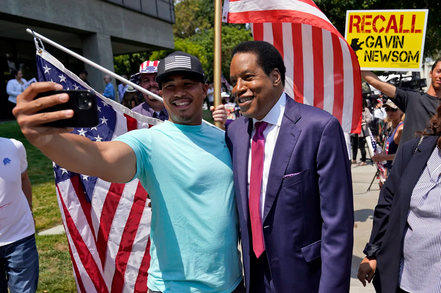 Radio talk show host Larry Elder, center, poses for a selfie with a supporter during a campaign stop in Norwalk, Calif., on July 13. 