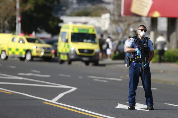 A police officer stands outside an Auckland supermarket, Friday.