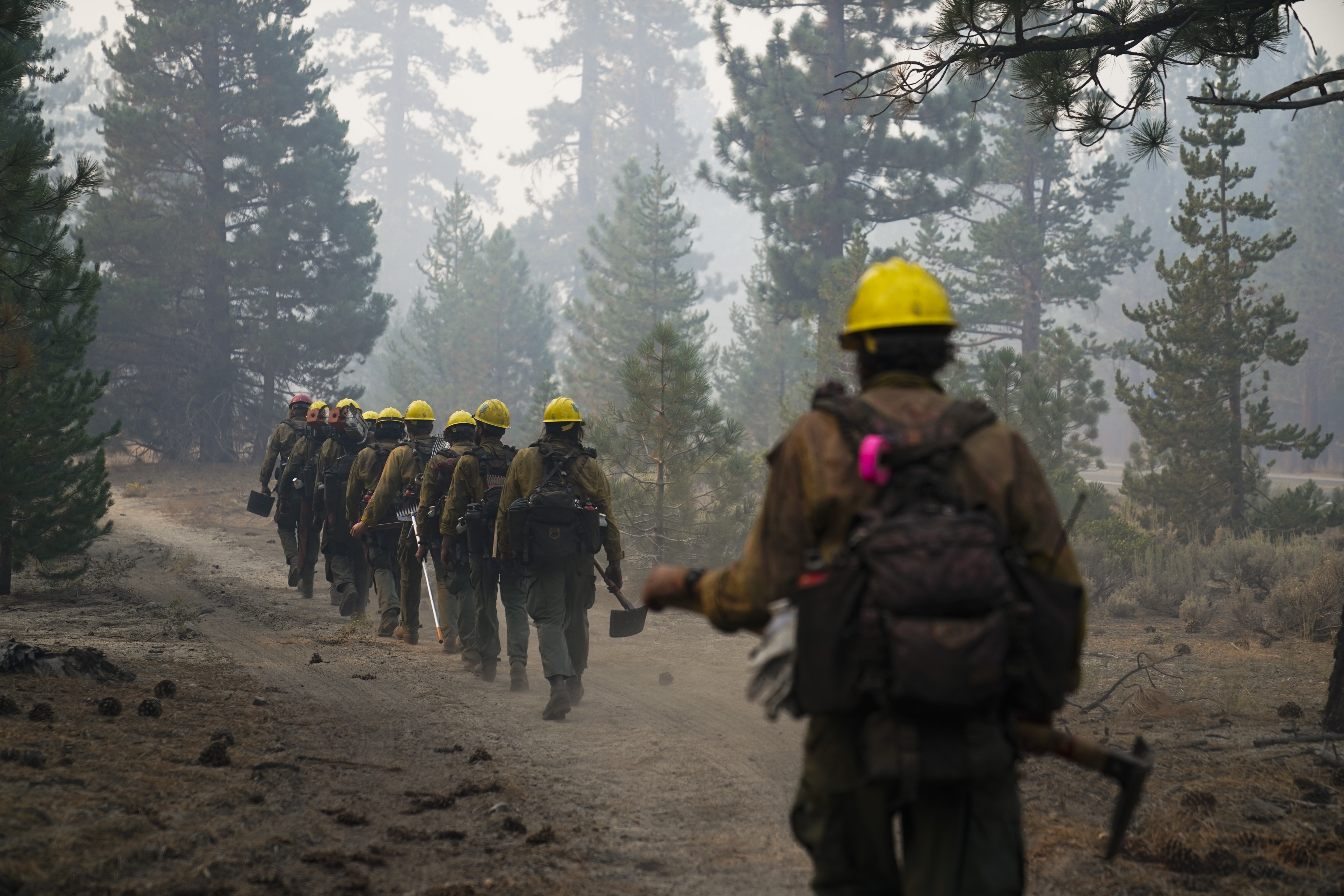 A hotshot crew from Tahoe Hotshots hikes along a trail in Meyers, Calif., Friday. Fire crews took advantage of decreasing winds to battle a California wildfire near popular Lake Tahoe and were even able to allow some people back to their homes but dry weather and a weekend warming trend meant the battle was far from over.
