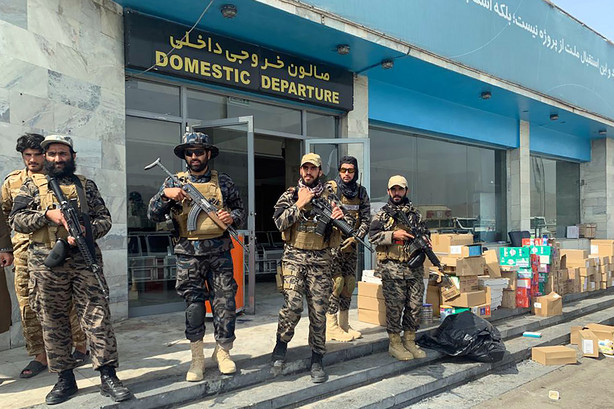 Taliban fighters stand guard inside the Hamid Karzai International Airport after the U.S. withdrawal in Kabul, Afghanistan, on Aug. 31. The Taliban, which is in need of foreign aid, has said it will allow people with valid travel papers to leave, and the international community says it will be monitoring to see if they keep their word.