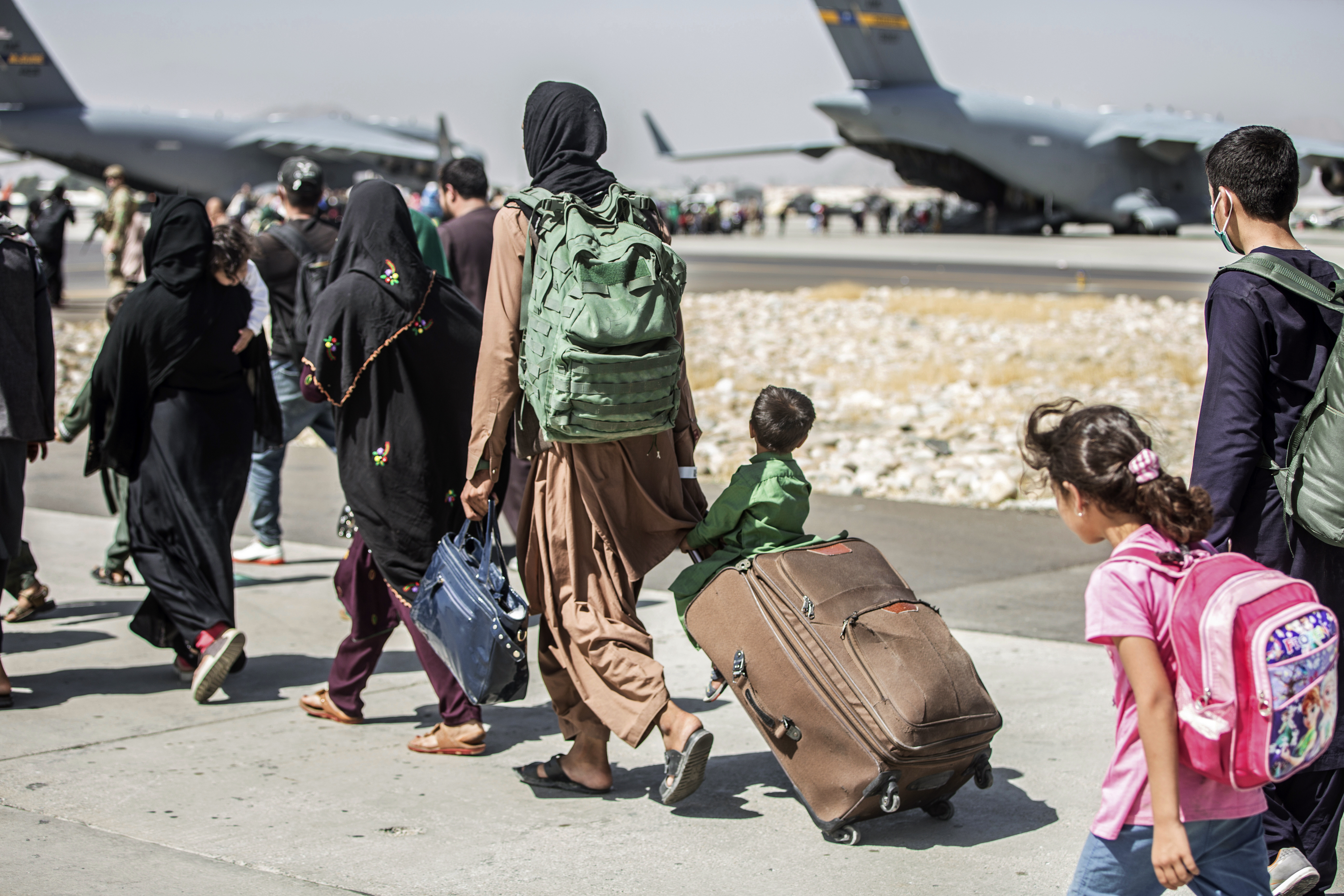 Families walk towards their flight during evacuations at Hamid Karzai International Airport, in Kabul, Afghanistan.