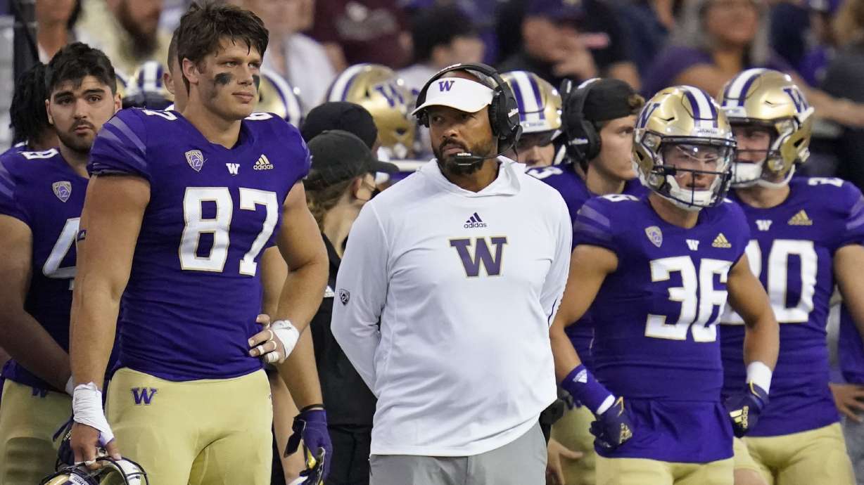 Washington head coach Jimmy Lake, center, stands with teammates on the sidelines against Montana late in the second half of an NCAA college football game Saturday, Sept. 4, 2021, in Seattle. Montana won 13-7.