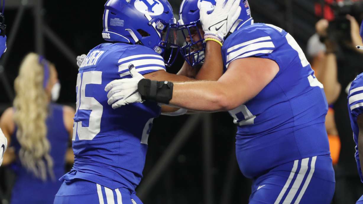 Brigham Young Cougars running back Tyler Allgeier (25) celebrate his touchdown with Brigham Young Cougars defensive lineman Uriah Leiataua (58) during the Vegas Kickoff Classic in Las Vegas on Saturday, Sept. 4, 2021.