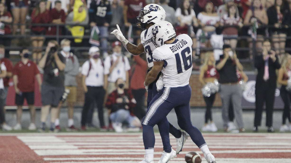 Utah State wide receiver Deven Thompkins, left, celebrates his touchdown with wide receiver Brandon Bowling during the second half of an NCAA college football game against Washington State, Saturday, Sept. 4, 2021, in Pullman, Wash. Utah State won 26-23.